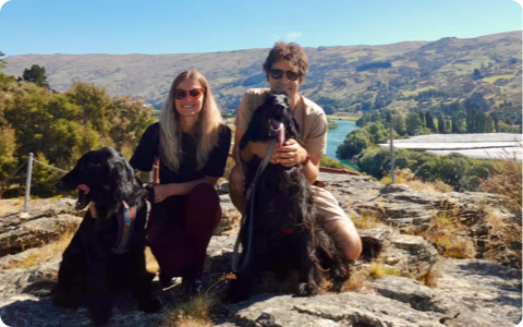 Photo of Natalia and Matt with their flat-coated retrievers Phoebe and Marley